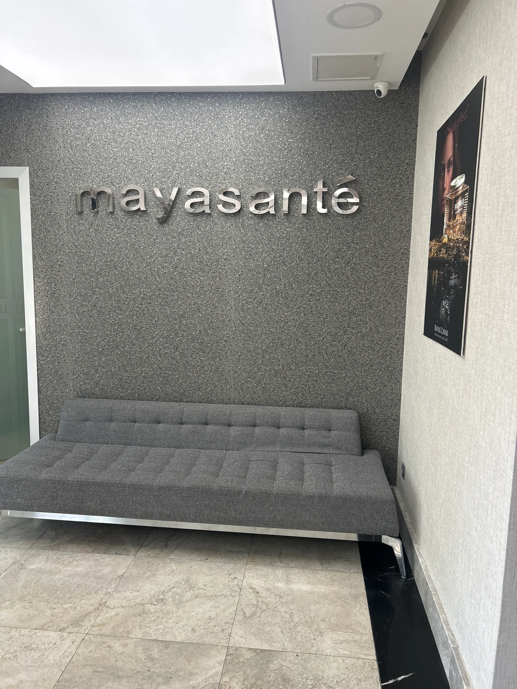 Özel Mayasante Polikliniği bekleme alanında logo duvarı ve kanepe